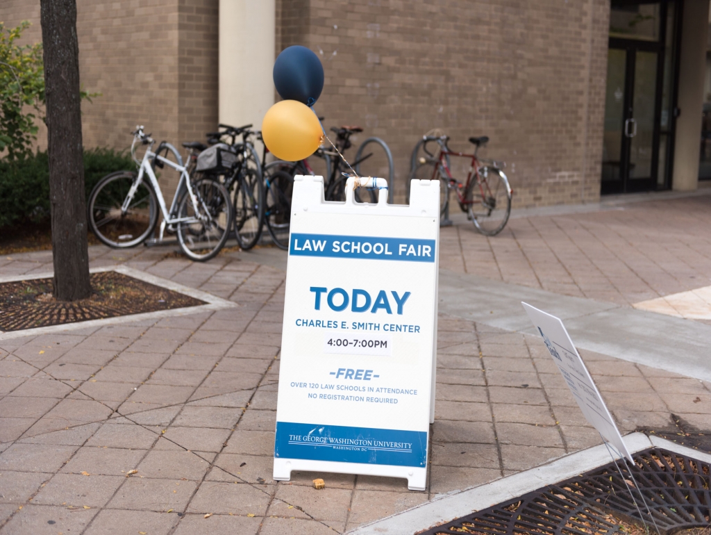 A law school fair sign on a sidewalk